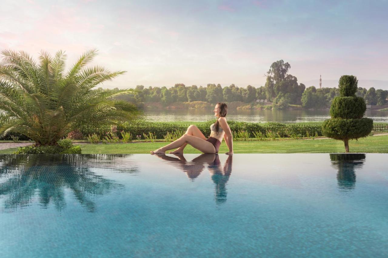 Jolie Ville Hotel & Spa Kings Island Луксор Екстер'єр фото A woman sitting on the edge of a pool